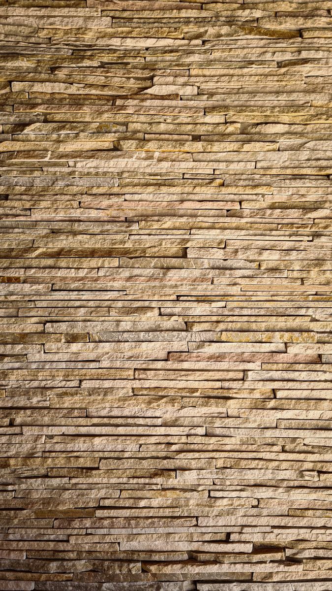 Close-up view of a textured stone wall showcasing linear patterns and natural colors.